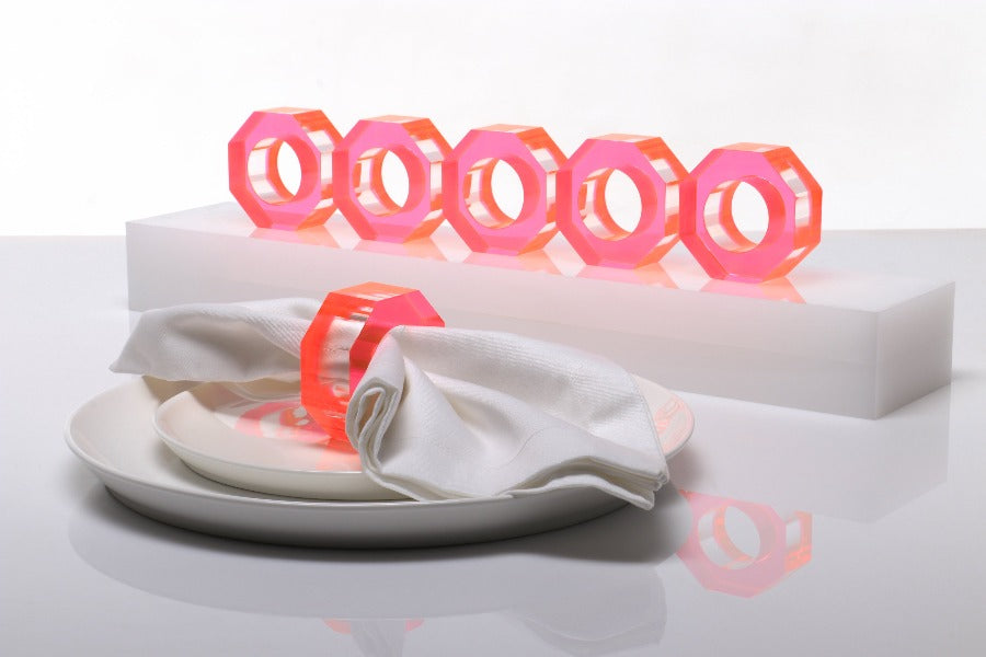 Alexandra Von Furstenberg Acrylic Dinner Napkin Rings in Pink showing 6 rings with a napkin in one. 