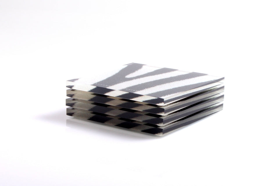 Alexandra Von Furstenberg Acrylic lucite drink coasters in zebra print stacked in a pile.