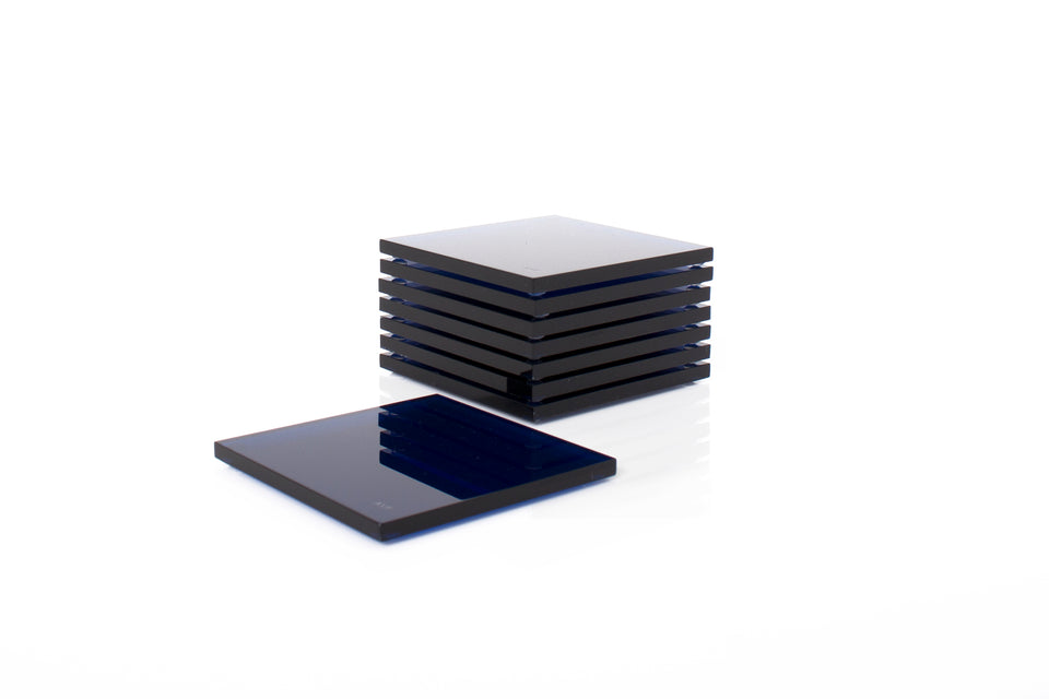 Alexandra Von Furstenberg Acrylic lucite drink coasters in sapphire stacked in a pile.