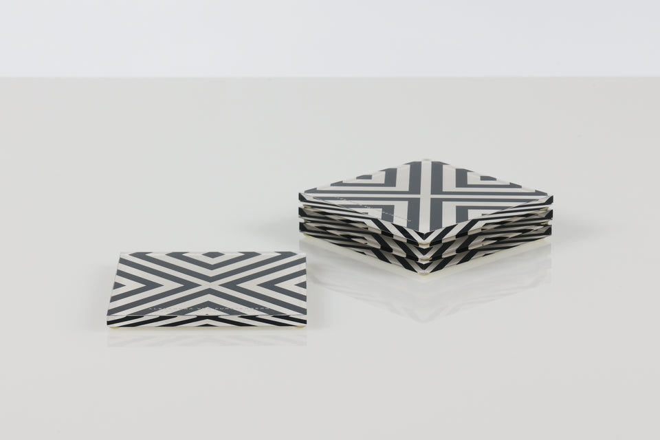 Set of X-Print coasters black and white. sitting on a white table. 