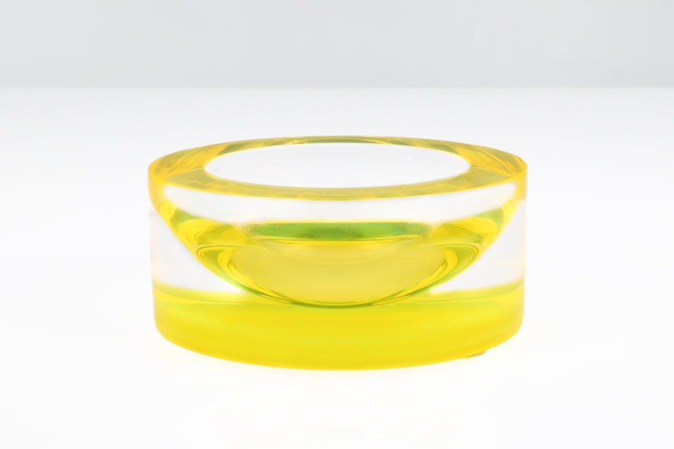 Yellow bowl, close up on a white table and a grey background.