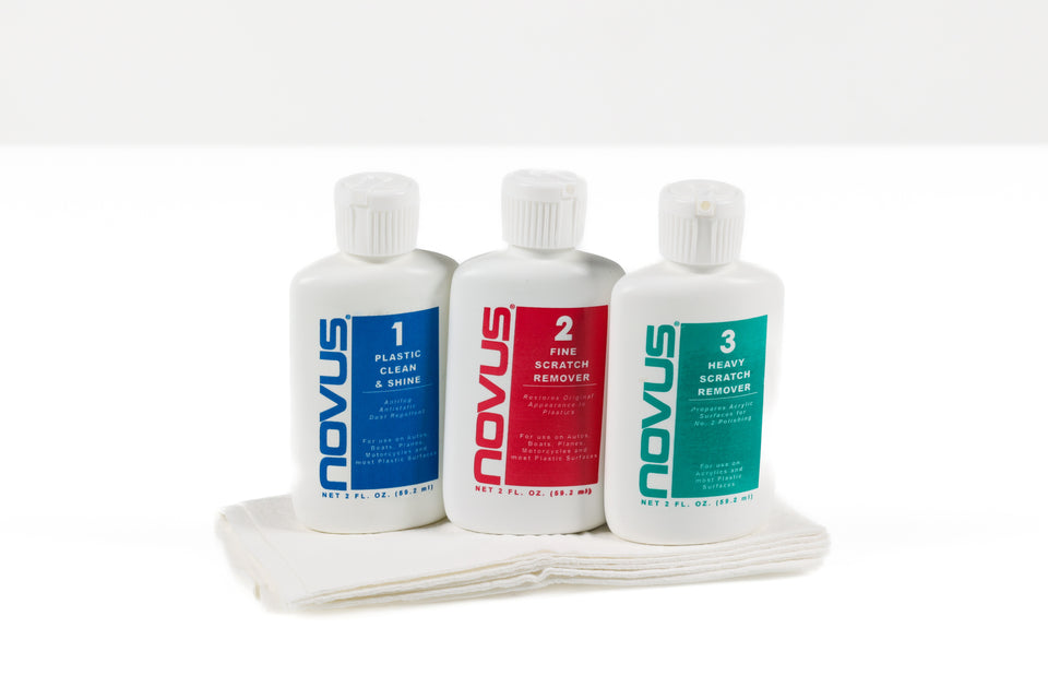 Three bottles of Novus car care products with a towel on a white background