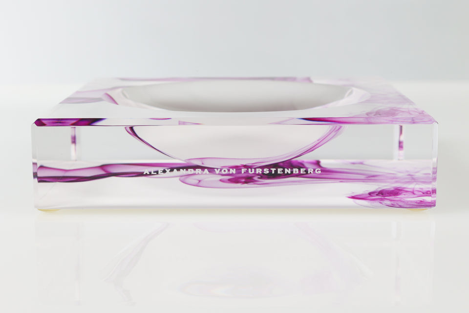 Acrylic candy bowl with a purple and white smoke pattern. Zoomed in on the Alexandra Von Furstenberg logo. 
