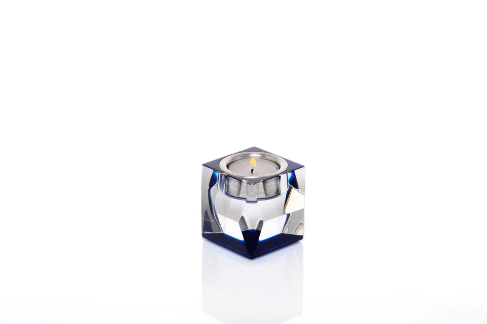 Sapphire short candleholder with a lit votive candle with a whitebackground