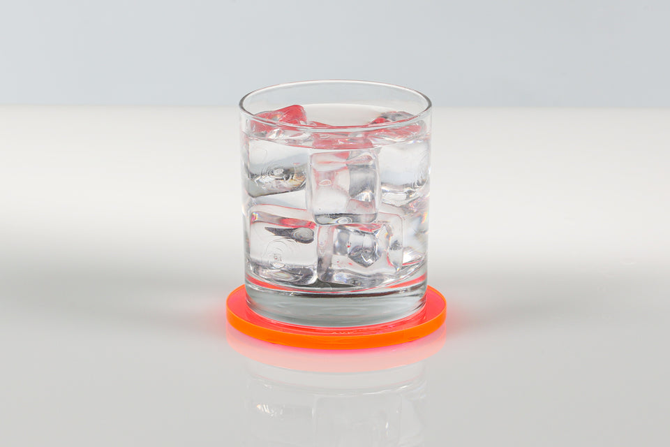Clear glass of water with ice cubes on a pink AVF bullseye coaster