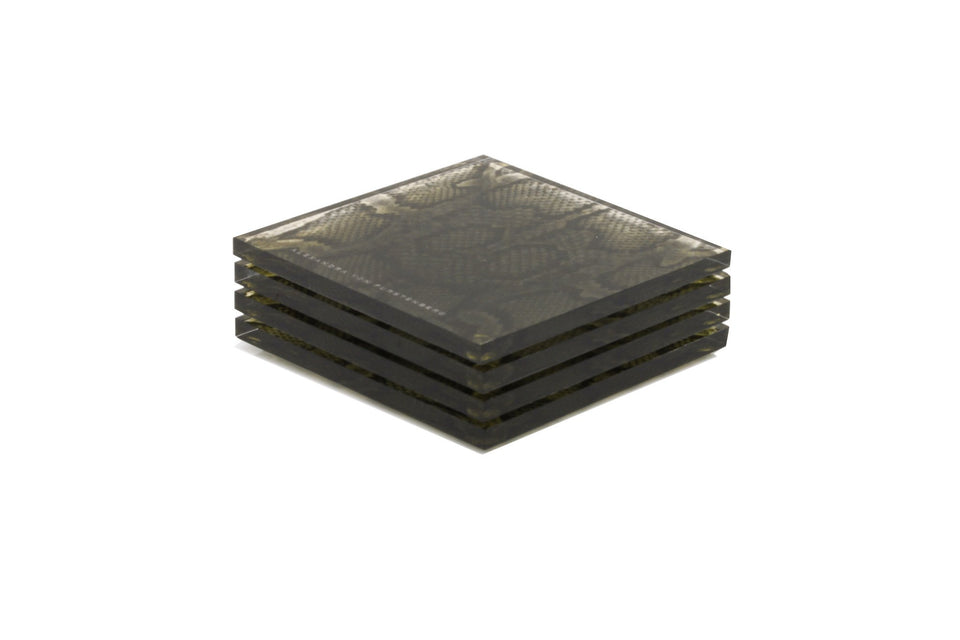 Alexandra Von Furstenberg Acrylic lucite drink coasters in snakeskin print stacked in a pile.