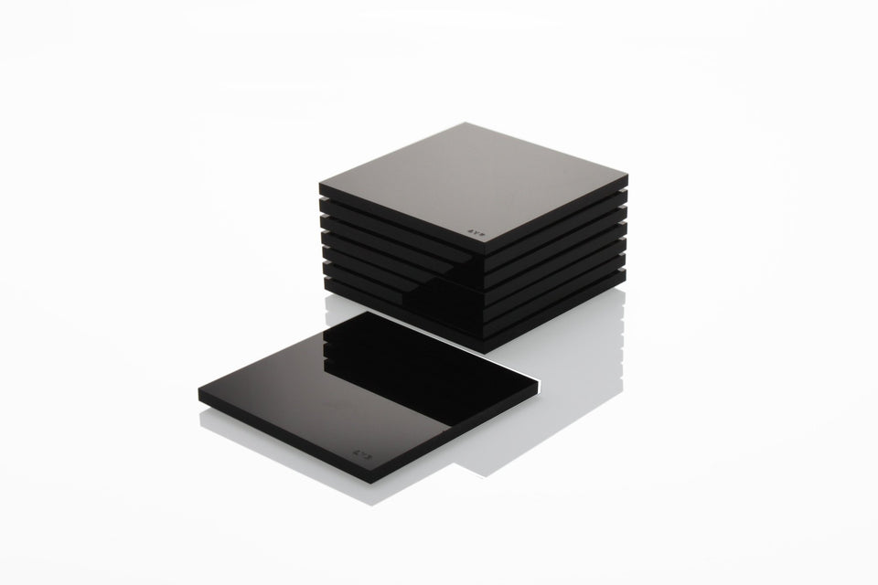 Alexandra Von Furstenberg Acrylic lucite drink coasters in black stacked in a pile.