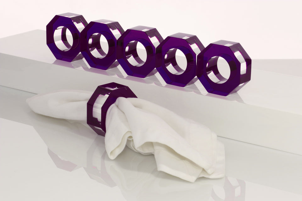 Alexandra Von Furstenberg Acrylic Dinner Napkin Rings in Amethyst showing 6 rings with a napkin in one. 