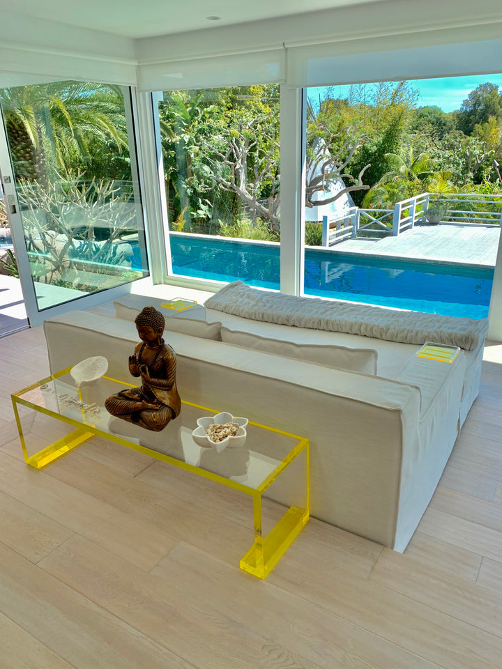 Alexandra Von Furstenberg Yellow Acrylic Low Profile Console table inside a room behind designer couch in luxury home