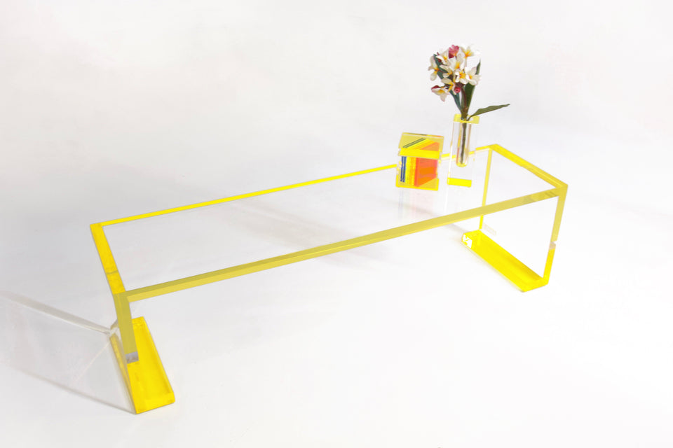 Alexandra Von Furstenberg Yellow Acrylic Low Profile Console table with flower and box on it.