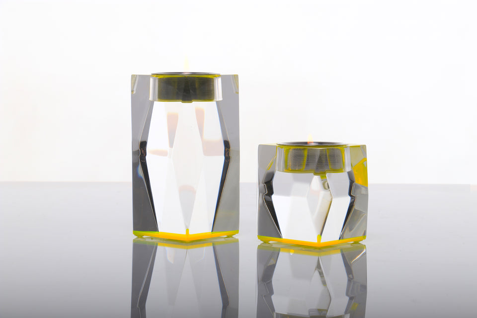 Yellow votive tea light pair of acrylic candleholders viewed from the side on a white background