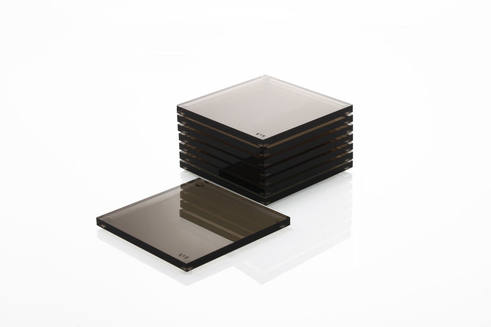 Alexandra Von Furstenberg Acrylic lucite drink coasters in bronze stacked in a pile.