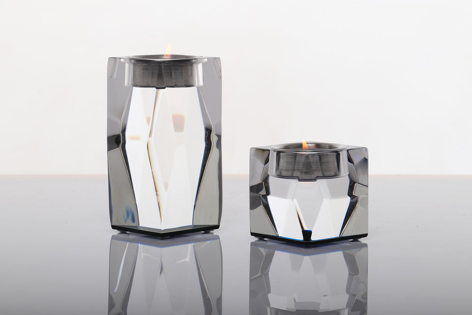 Lucite luxury candleholder pair, short and tall. Candles are lit are viewed close up. 